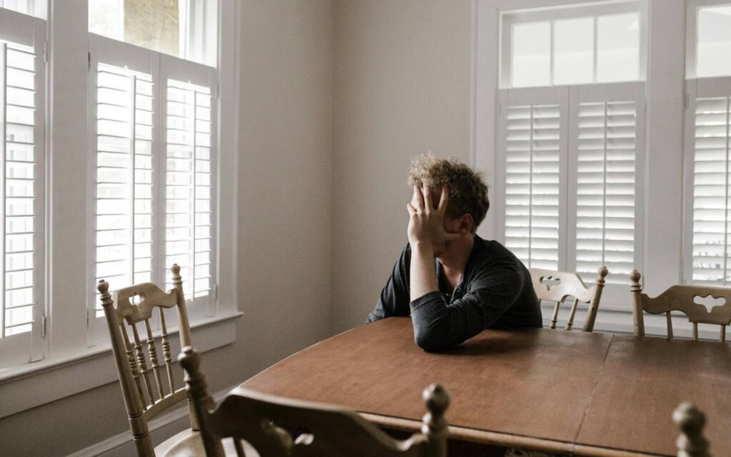 Čovek u depresiji sedi za stolom Čovek u depresiji sedi za stolom